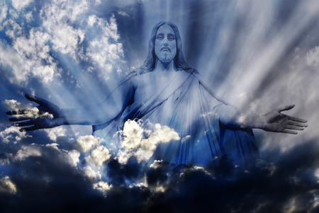 30575602 - jesus standing in white and gray storm clouds in blue sky with rays of light